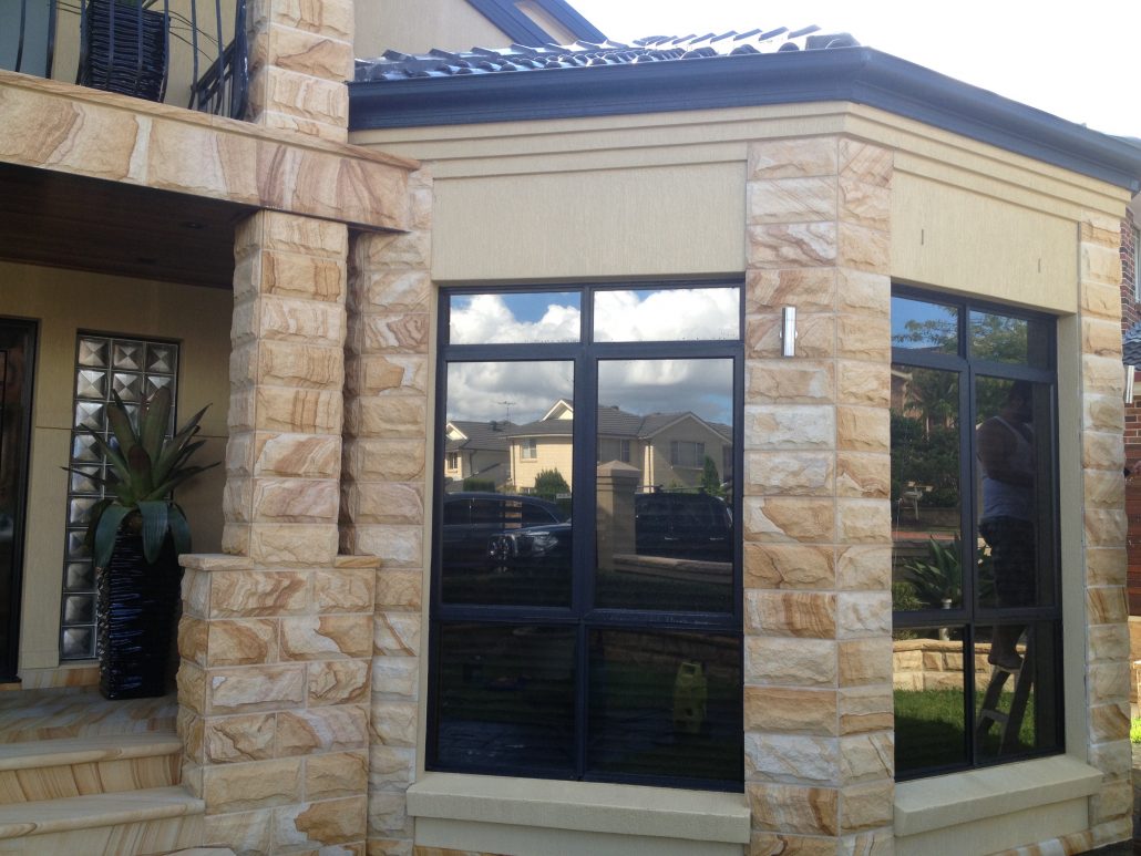 Sandstone pillar and wall beside a bay window