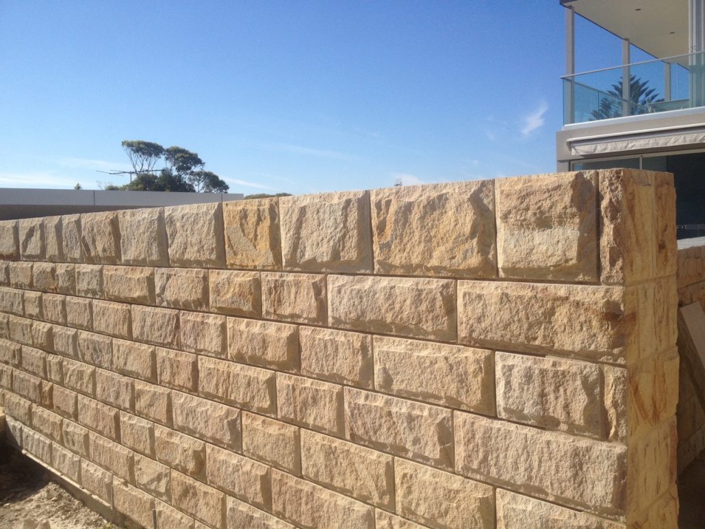 Sandstone block wall against a blue sky