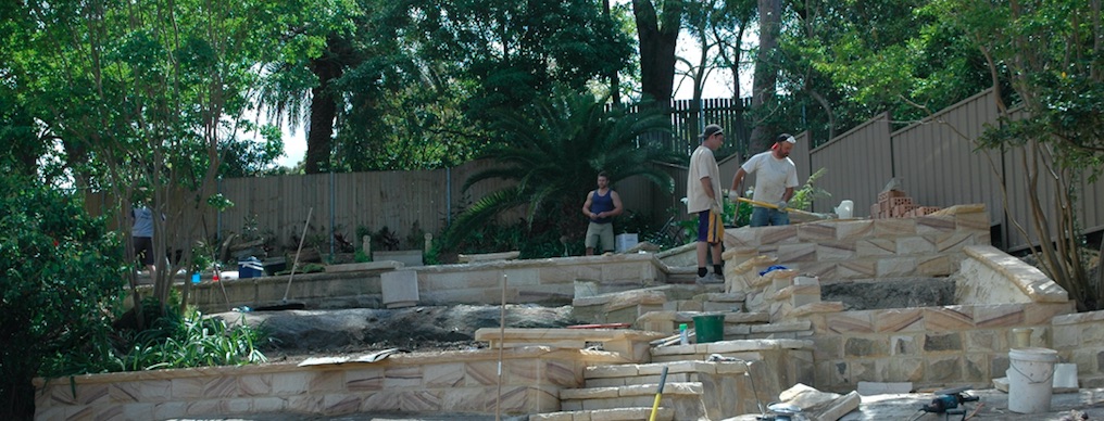 Stonemasons building a terraced garden wall