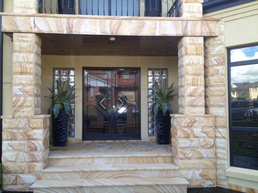 Sandstone entry steps and pillars at the front of a home