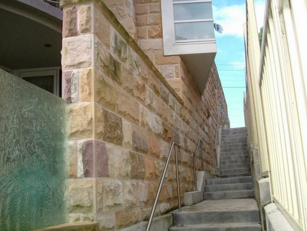 Sandstone-clad wall beside a narrow set of steps