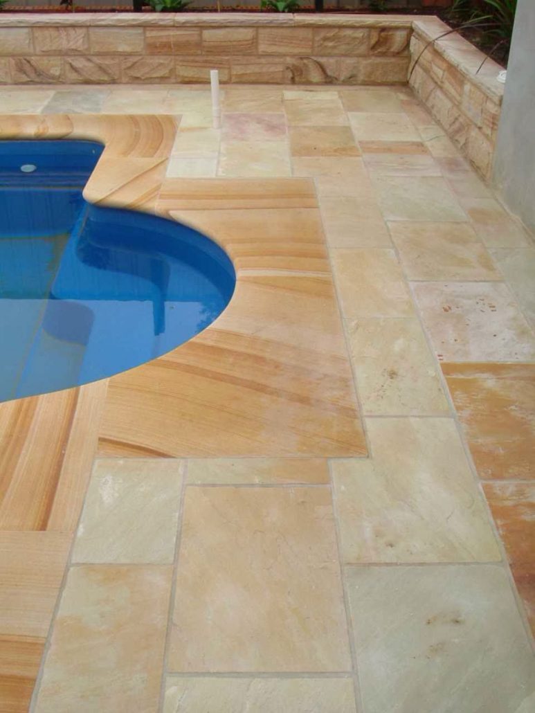 Sandstone paving beside a curved pool edge