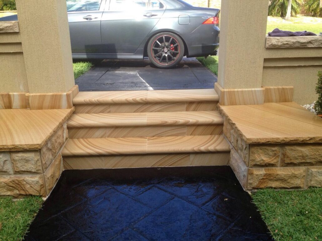 Sandstone steps with seating ledges beside a driveway